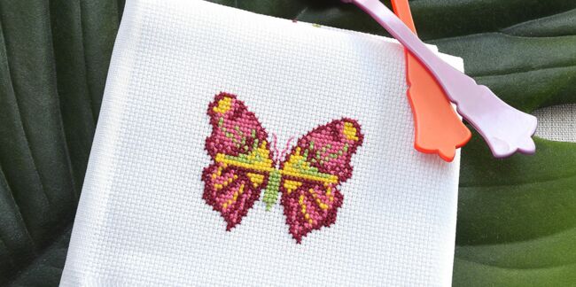 Broderie : un papillon multicolore au point de croix