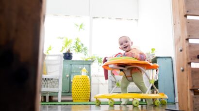 Jeune Femme Qui Pousse Son Bébé Dans La Poussette Sur Le Trottoir