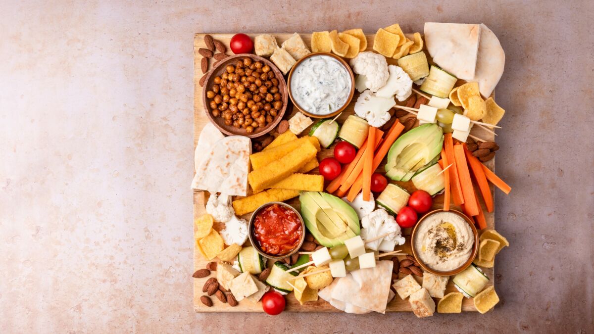 Planche apéro avec chiffre, garnie avec de la charcuterie, du fromage et  des crudités