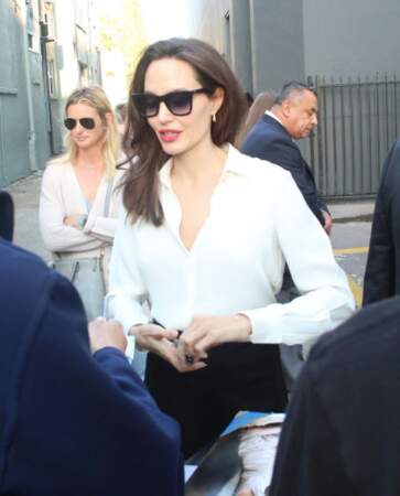 Angelina Jolie en chemisier blanc et lunettes noires