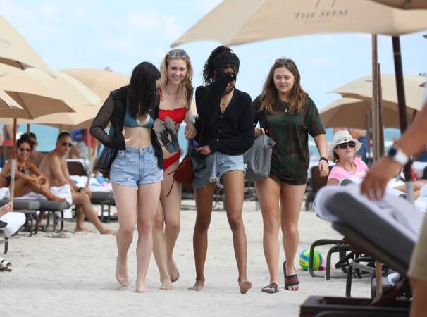 Malia Obama wears a white bikini as she relaxes with friends on the beach in Miami