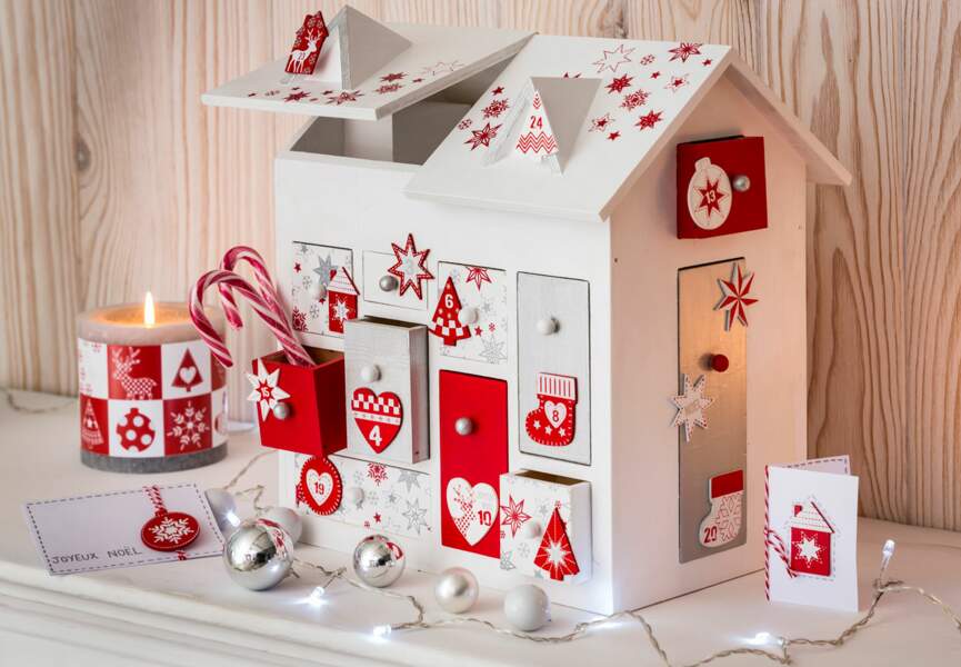 Une décoration de Noël tradi en rouge et blanc avec... Un calendrier de l'avent en forme de maison