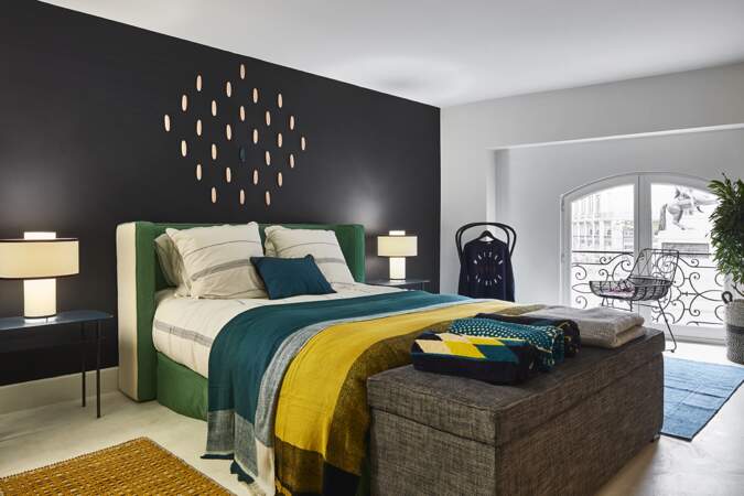 Chambre design avec mur noir et linge coloré