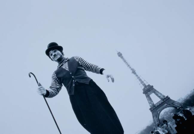 Un mime habillé comme Charlie Chaplin devant la Tour Eiffel