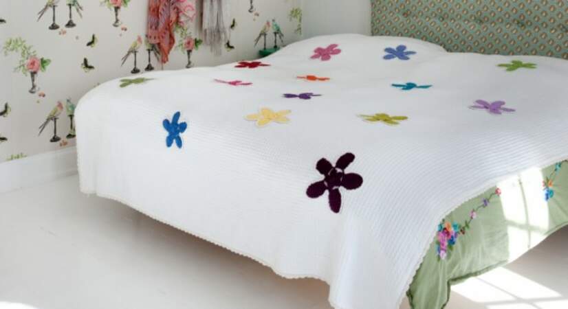 Une fleur crochetée à coudre sur un dessus de lit