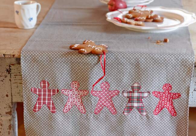 Une décoration de Noël tradi en rouge et blanc avec... Un chemin de table à bonshommes