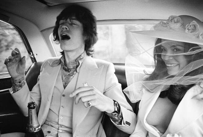 ... Mick Jagger et Bianca Jagger dans leur voiture trinquant avec du champagne après la cérémonie du mariage.