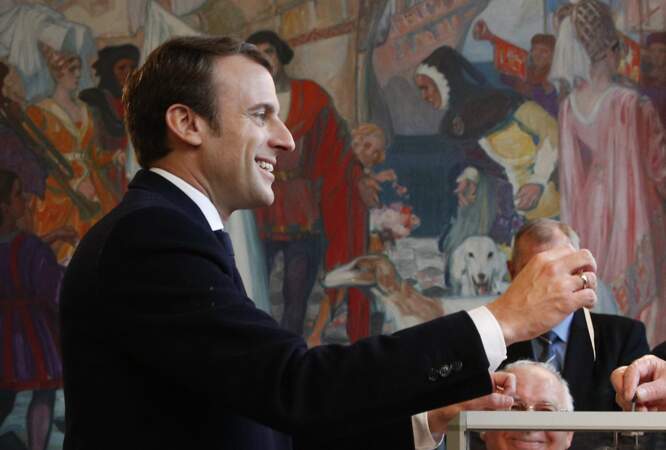 Sûr de lui, Emmanuel Macron affiche un beau sourire au moment de déposer son bulletin.