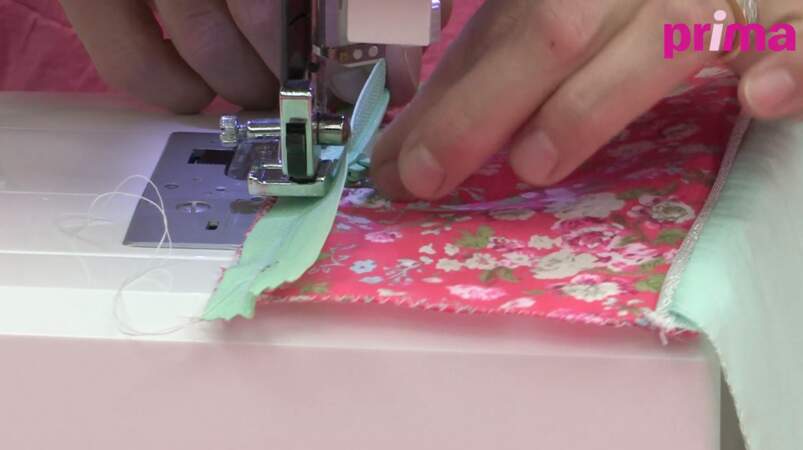 Cousez la fermeture à glissière à la machine sur le tissu floral au point droit