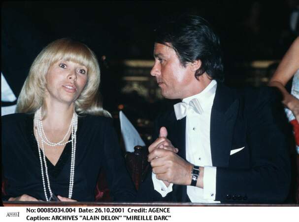 Mireille Darc et Alain Delon assistent à un spectacle en février 1980.