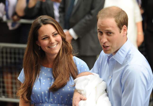 Le prince William prend finalement le prince George dans ses bras devant les photographes, le 23 juillet 2013