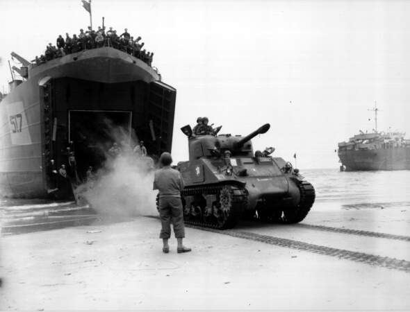 Un char Sherman s'élance sur le sol de France en sortant d'un bateau