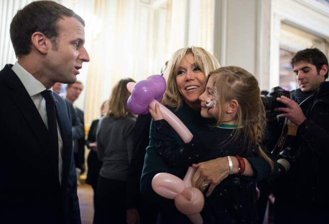 Brigitte Macron prend une enfant dans ses bras