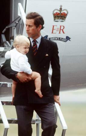 Le prince William dans les bras de son père Charles, prince de Galles, à l'aéroport d'Aberdeen en Écosse, en 1983.