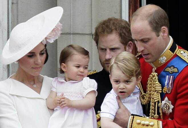 La princesse Charlotte, dans les bras de sa mère, entouré par son frère George, son père William et son oncle Harry, le 11 juin 2016, sur le balcon de Buckingham Palace.