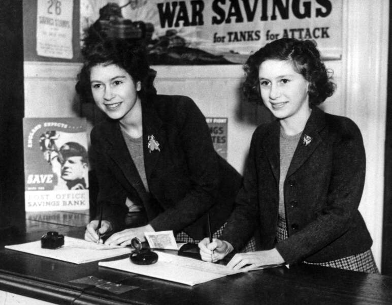 La princesse Elizabeth et sa soeur la princesse Margaret achètent des timbres d'épargne de guerre, à la Poste, en 1944.