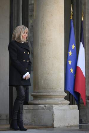 Brigitte Macron en manteau noir à double boutons dorés