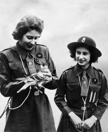 La princesse Elizabeth et la princesse Margaret, scouts, s'apprêtent à envoyer un message à Lady Baden-Powell par le biais d'un pigeon voyageur, en février 1943.