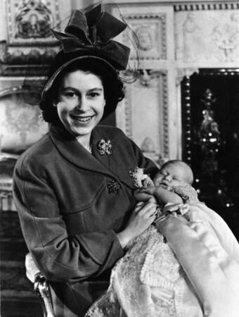 La princesse Elizabeth tient dans ses bras son fils, le prince Charles, après son baptême à Buckingham Palace, le 14 décembre 1948.