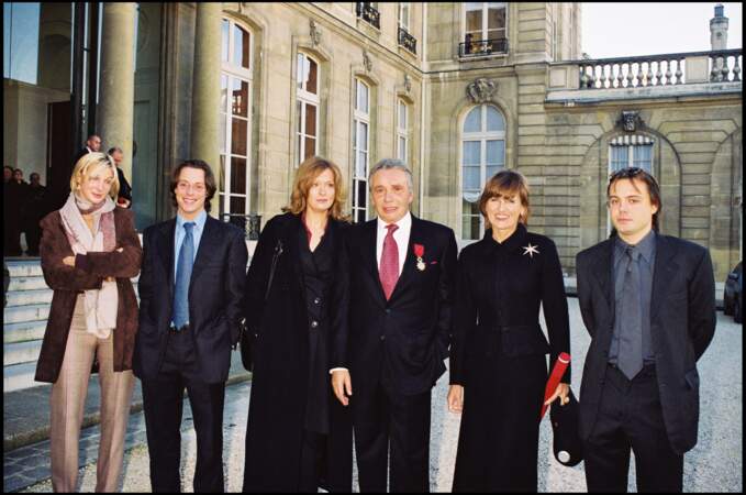 Michel Sardou reçoit la Légion d'honneur, à l'Élysée, aux côtés de sa femme et de ses enfants Cynthia, Romain et Davy, le 16 novembre 2001.