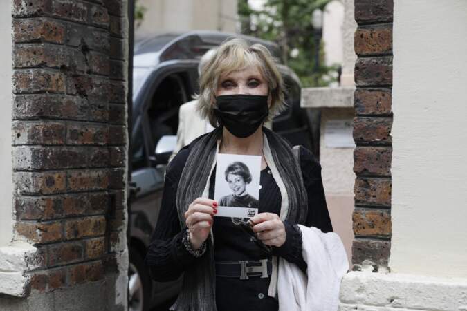Sophie Darel, tenant une photo de Jacqueline Caurat, à la sortie des obsèques de la journaliste.