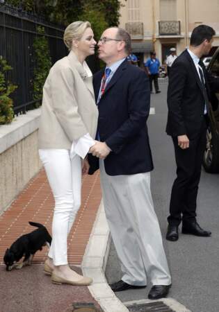 Petit moment d'intimité entre le prince Albert II et la princesse Charlène de Monaco, avec son chien Monté, en aparté d'une visite aux spectateurs de la tribune de l'association monégasque des handicapés moteur, lors des essais du Grand Prix de Monaco, le 23 mai 2015.