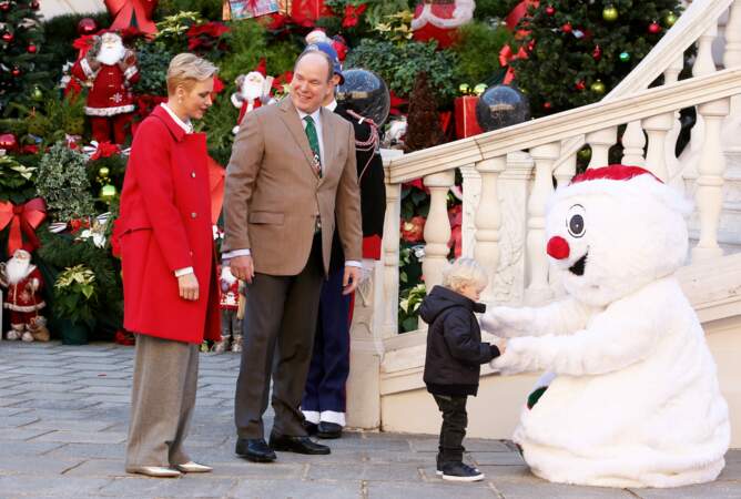 Jour de cadeaux, le 14 décembre 2016, où le couple princier va à la rencontre des petits monégasques, accompagné par le prince Jacques de Monaco, subjugué par le bonhomme de neige en peluche.