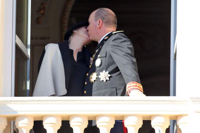 La princesse Charlène, enceinte, et le prince Albert II de Monaco s'embrassent tendrement, au balcon du Palais princier, lors de la fête nationale monégasque, le 19 novembre 2014.