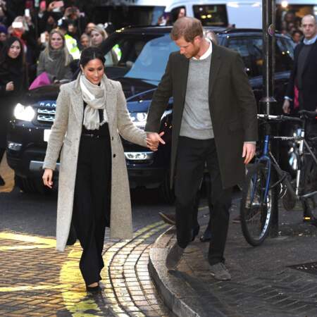 Le prince Harry, prévenant envers sa compagne Meghan Markle, quittent la station de radio "Reprezent" dans le quartier de Brixton, à Londres, le 9 janvier 2018.