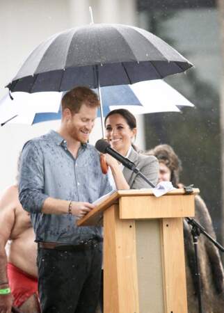 C'est sous un parapluie, tenu par la duchesse de Sussex, que le prince Harry a fait son discours, au parc Victoria Park de la ville de Dubbo, dans le cadre de leur première tournée officielle, le 17 octobre 2018.
