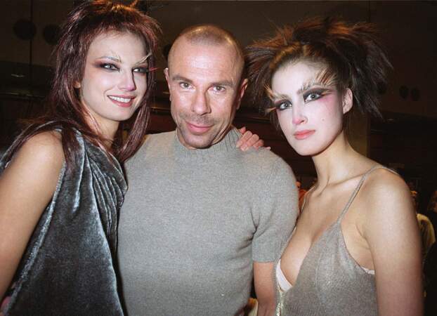Le couturier entouré de deux mannequins en backstage de son défilé de mode. 