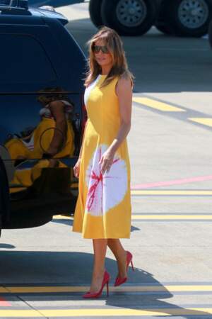 Melania Trump toujours aussi chic dans une robe jaune avec des motifs assortis à ses chaussures rouges.