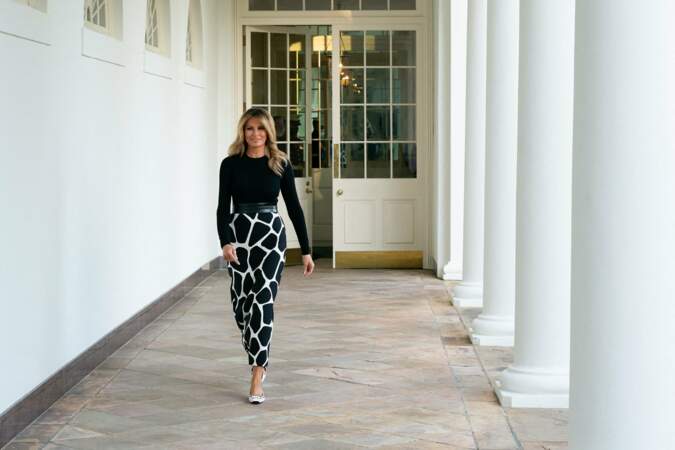 Look noir et blanc pour Melania Trump qui porte un top noir sur une jupe tube longue au motif girafe.