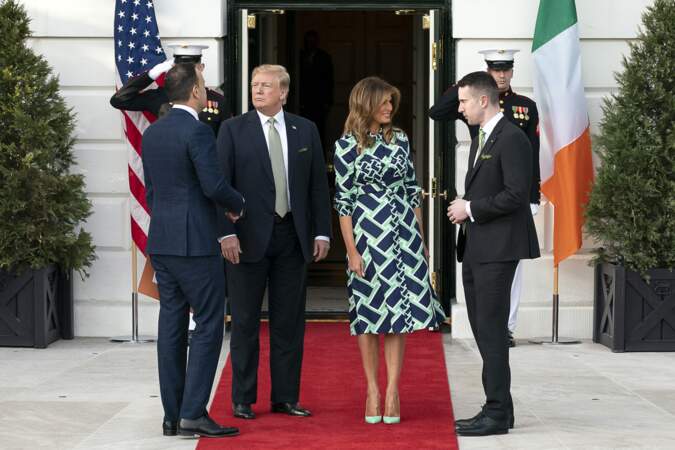 Melania Trump dans une robe aux motifs géométriques, aux teintes marine et verte. D'un vert assorti à ses escarpins.