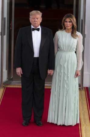 Melania Trump dans une robe longue plissée vert d'eau avec des manches transparentes.