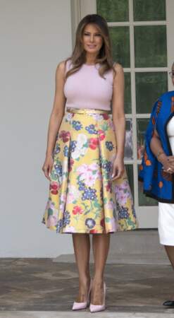 Melania Trump en top moulant rose pâle assortie aux escarpins, sur une jupe fleurie évasée. 