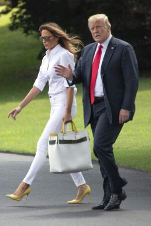 Melania Trump en total look blanc, jean slim et chemisier, avec les escarpins assorties aux poignées de son sac. 