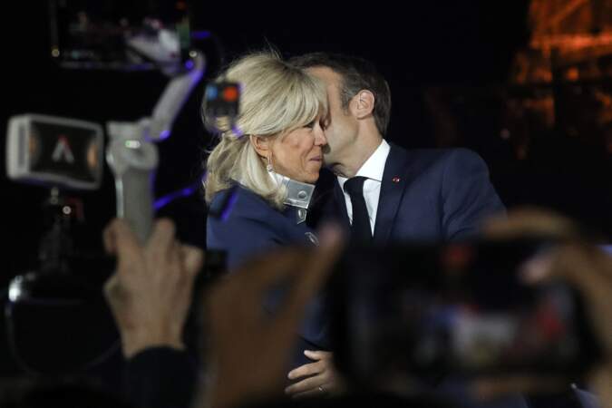 Le président Emmanuel Macron embrasse sa femme Brigitte le soir de sa victoire à l'élection présidentielle, le  24 avril 2022, au Champ-de-Mars à Paris.