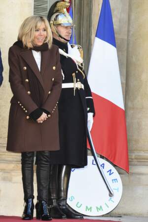 Brigitte Macron en long manteau marron à boutons dorés